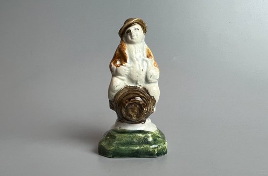 Eine c1790 Staffordshire pratt farbige Perlware-Topper-Figur, die auf einem Fass sitzt.