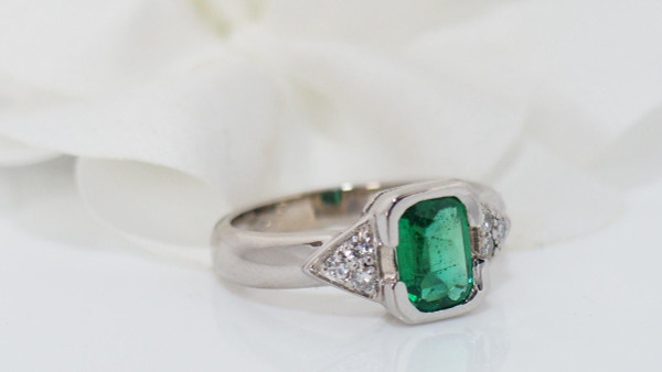 White Gold Ring Decorated With An Emerald And Diamonds