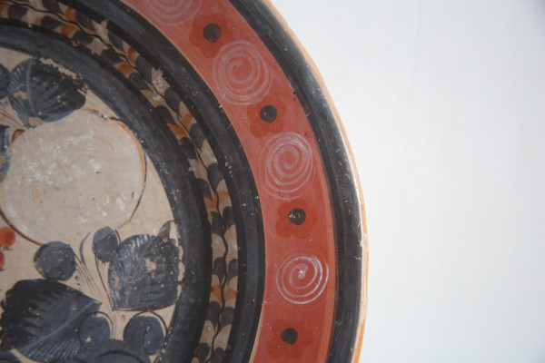 Large circular terracotta dish decorated with a fawn in a landscape.