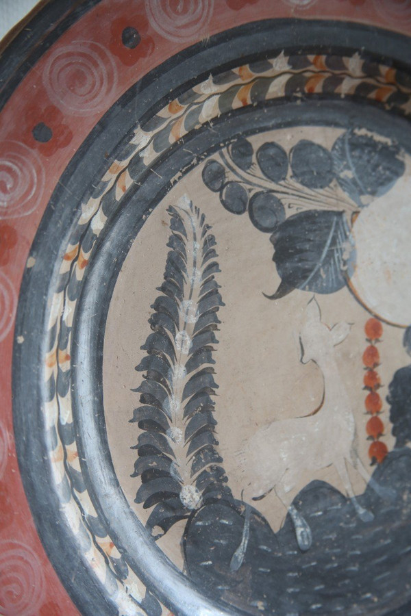 Large circular terracotta dish decorated with a fawn in a landscape.