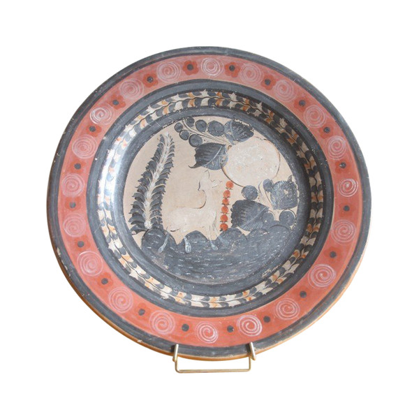 Large circular terracotta dish decorated with a fawn in a landscape.