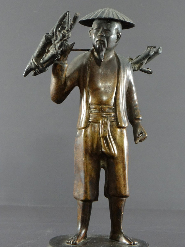 Vietnam, inizio XX secolo, Statuetta in bronzo Contadino che trasporta fascine.