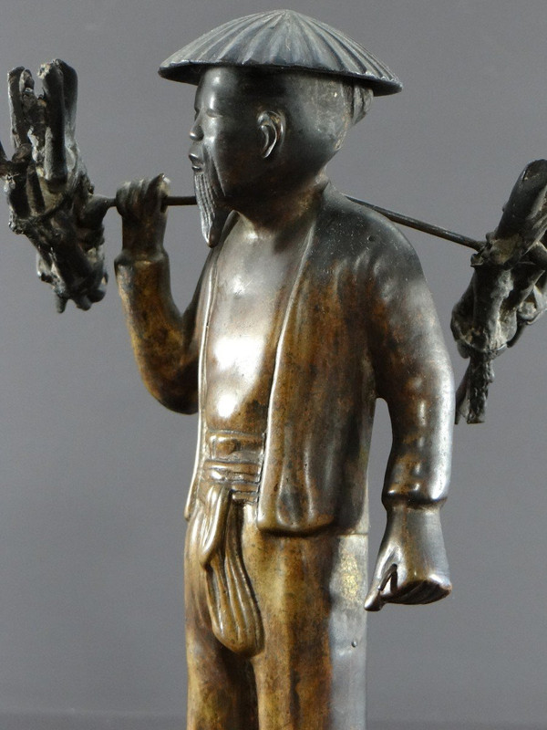 Vietnam, inizio XX secolo, Statuetta in bronzo Contadino che trasporta fascine.