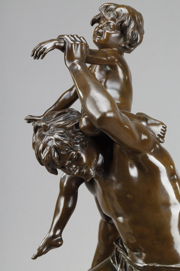 BROWN PATINA BRONZE OF A MAN CARRYING A CHILD ON HIS BACK, BY GASTON LEROUX (1854-1942)