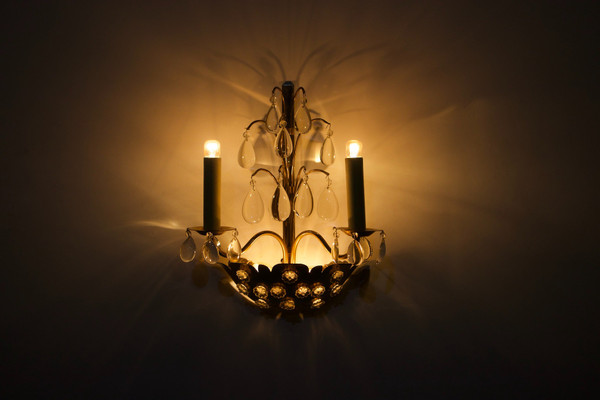 Brass floral sconce with pendants.