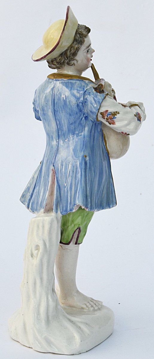 Porcelain statuette depicting a young boy playing the bagpipes