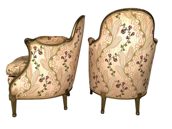 Paire de bergères en bois doré garnies de soie à motifs de fleurs, art déco d’inspiration Louis XVI