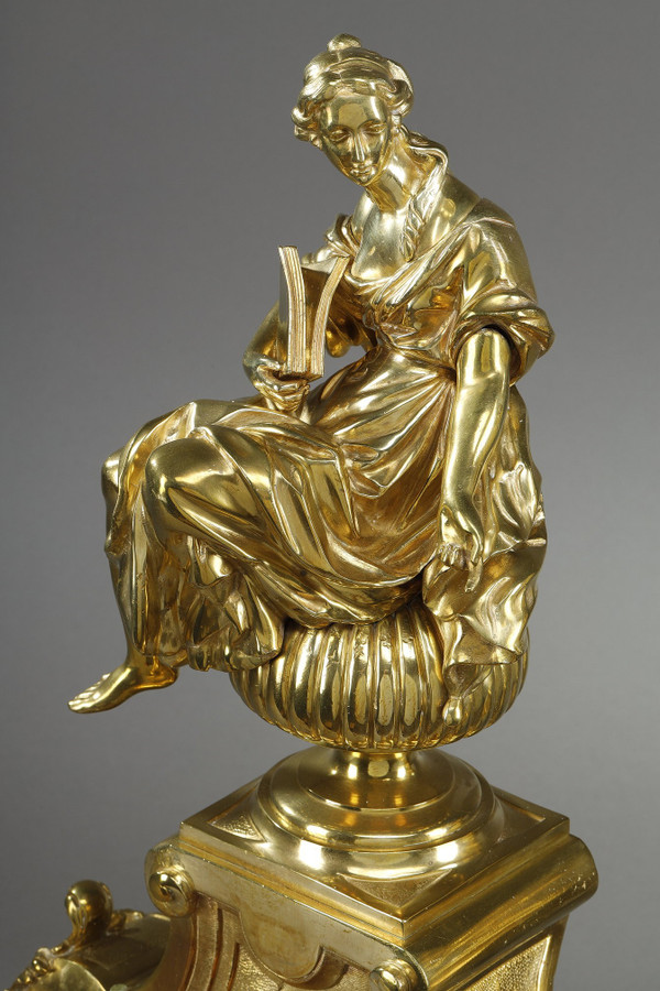 PAIR OF ORMOLU AND CHASED ANDIRONS DECORATED WITH SEATED MUSES