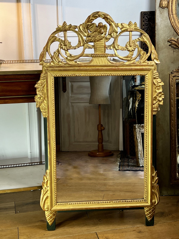 MIROIR EN BOIS SCULPTÉ DORÉ AVEC FRONTON AJOURÉ A DECOR DE FLEURS STYLE L.XVI