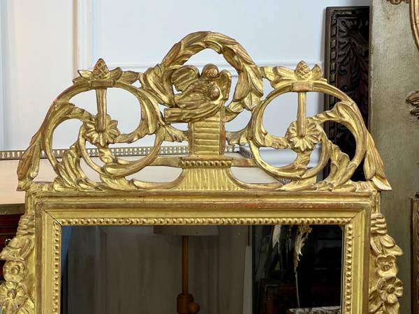 MIROIR EN BOIS SCULPTÉ DORÉ AVEC FRONTON AJOURÉ A DECOR DE FLEURS STYLE L.XVI