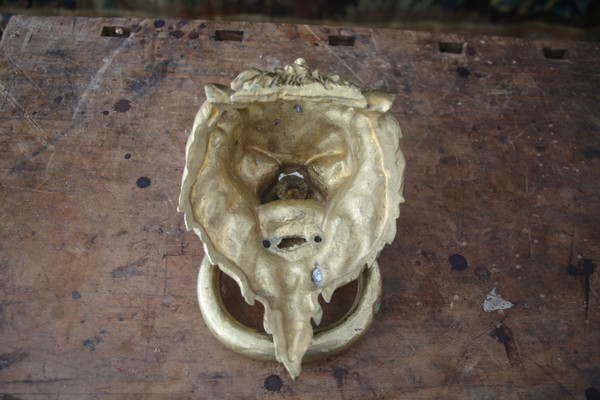 Gilt bronze knocker with lion's head, work from the 20th century.