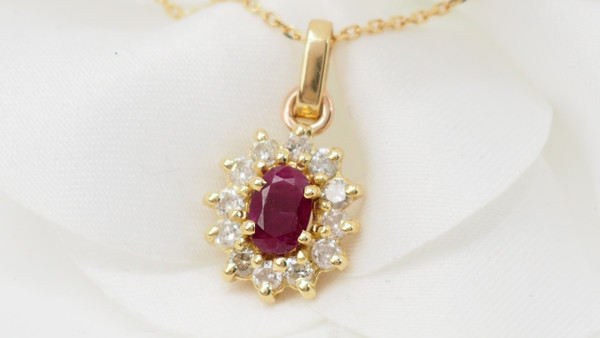 Collier pendentif marguerite en or jaune , rubis ovale et diamants 