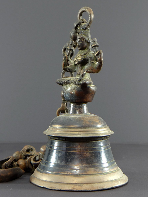 India, Mid-20th Century, Bronze bell adorned with a representation of the goddess Tripura.