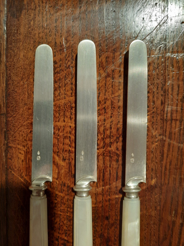 Eighteen solid silver and mother-of-pearl knives in a Napoleon III-era rosewood case.