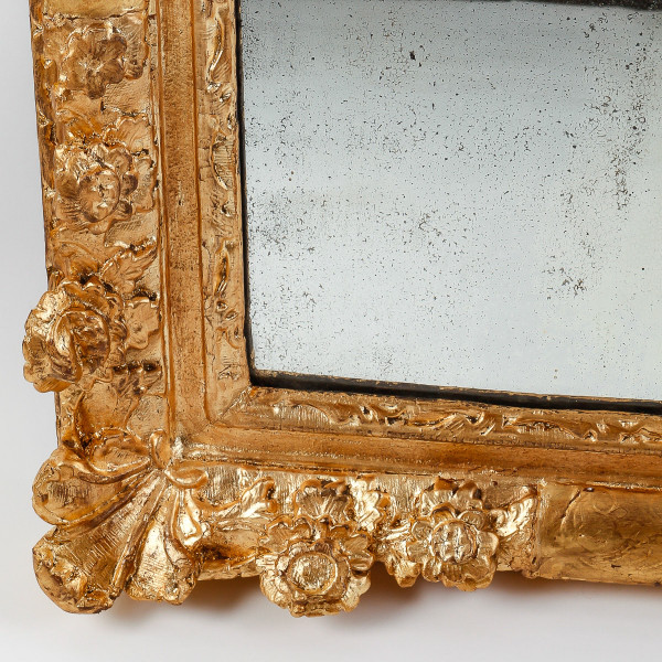 A French Regence period carved and gilt wood and stucco mirror circa 1720