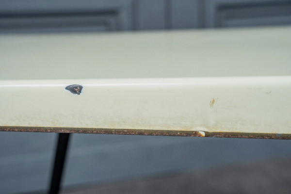 1960 coffee table with cream-colored top and designer tubular legs