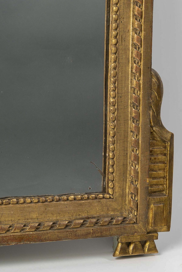 A large openwork pediment mirror in carved and gilded wood with musical attributes from the Louis XV