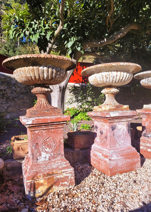 Set of 4 large cast iron garden vases on terracotta bases, 19th century