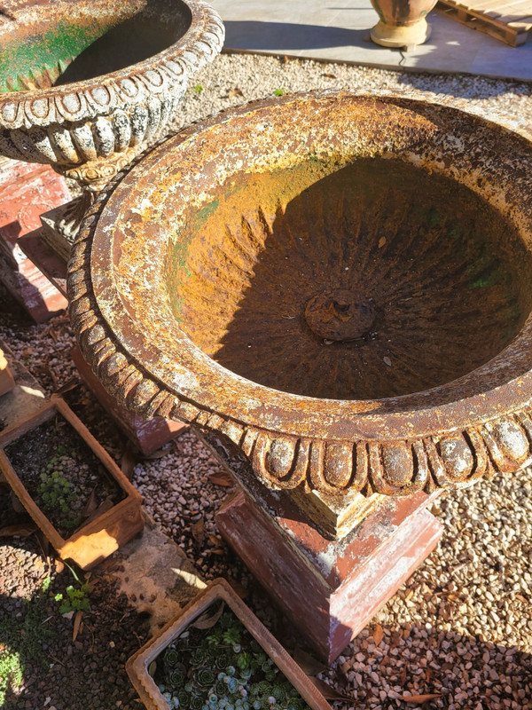 Set of 4 large cast iron garden vases on terracotta bases, 19th century