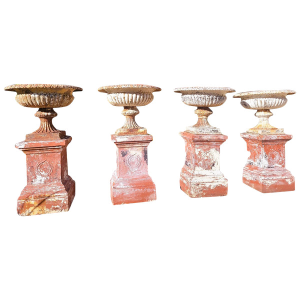 Set of 4 large cast iron garden vases on terracotta bases, 19th century