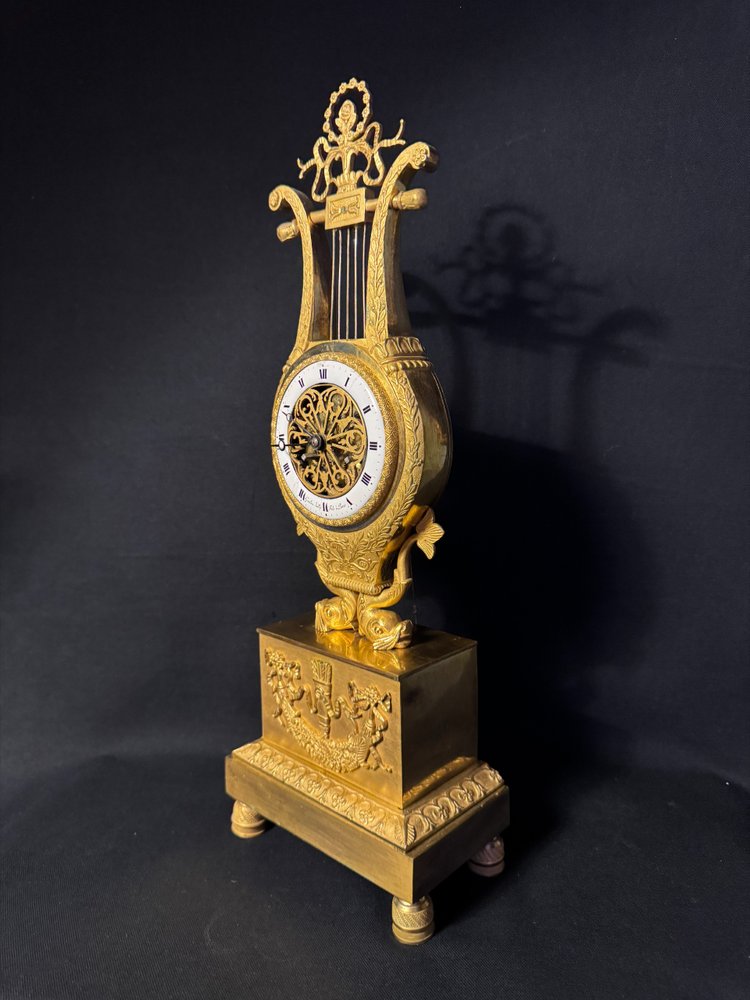 Pendule d’époque Empire Lyre aux dauphins en bronze doré