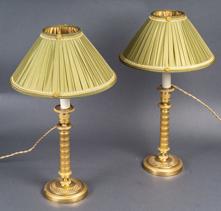 Coppia di candelieri in bronzo dorato e finemente cesellato di epoca Impero, montati come lampade, 1810 ca.