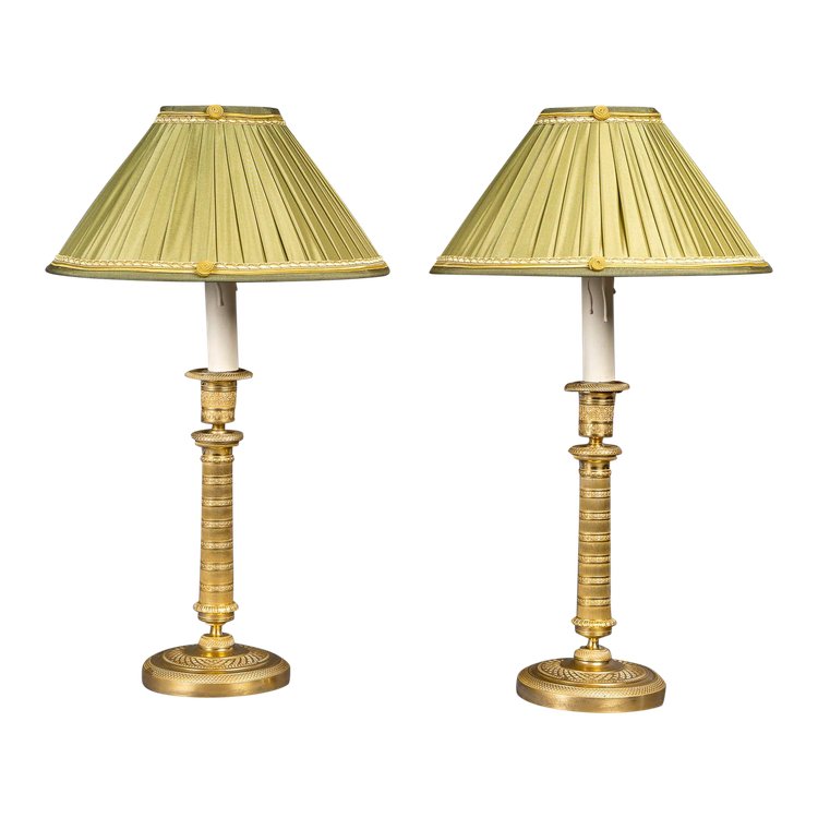 Coppia di candelieri in bronzo dorato e finemente cesellato di epoca Impero, montati come lampade, 1810 ca.