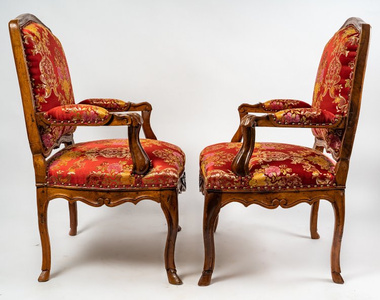 Paire de larges fauteuils en noyer mouluré et sculpté d’époque Régence vers 1720