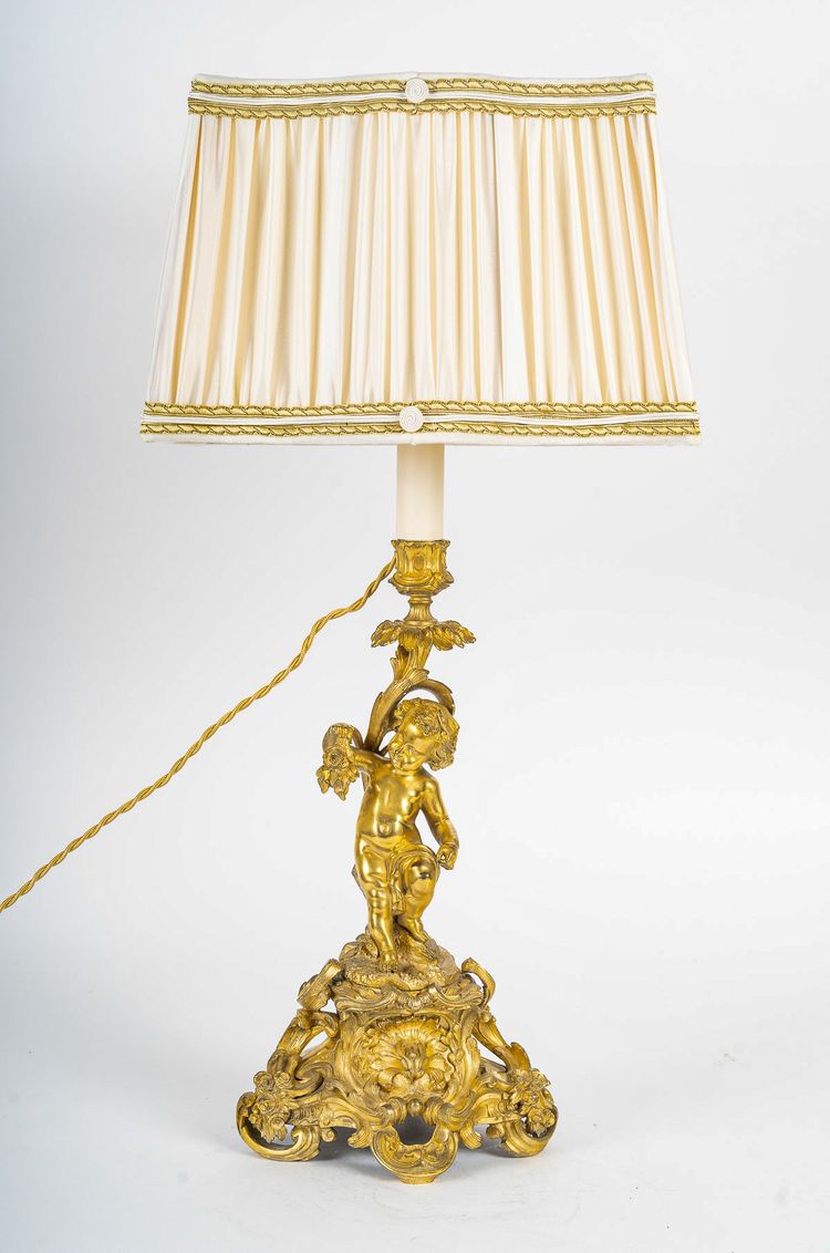 A pair of Napoleon III period gilt bronze Putti candlesticks, mounted as lamps