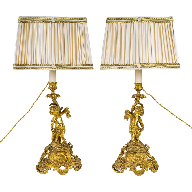 A pair of Napoleon III period gilt bronze Putti candlesticks, mounted as lamps