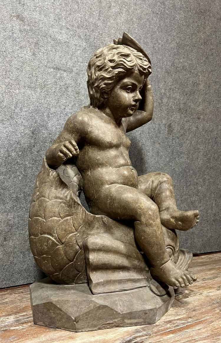 Italy, circa 1900: monumental marble statue of a Putto or cherub straddling a dolphin