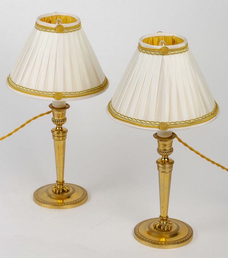 A pair of French Directoire period candlesticks converted as table lamps in chiseled and gilt bronze