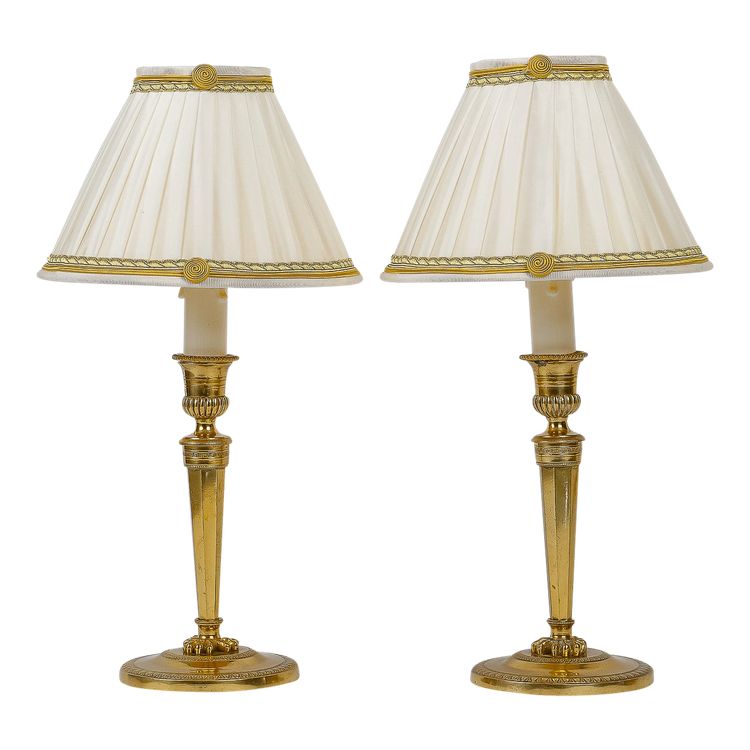 A pair of French Directoire period candlesticks converted as table lamps in chiseled and gilt bronze