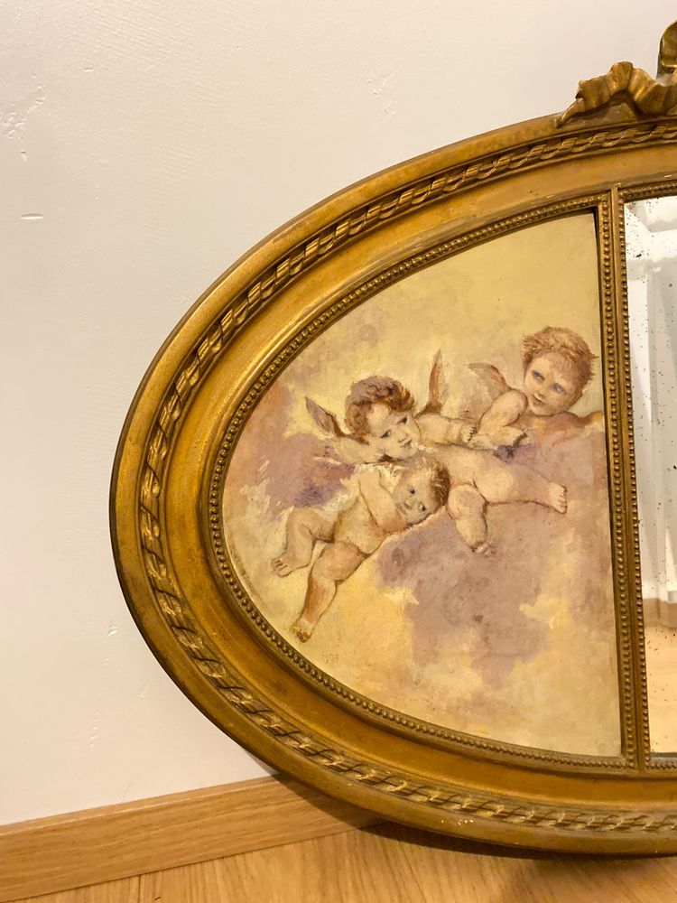 Gilded Oval Bevelled Mirror Surrounded By Two Paintings Of Cherubs 110cm X 70cm