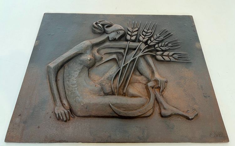 Modernist cast-iron plaque depicting a Nude Woman Holding a Scythe and Wheat Spikes.