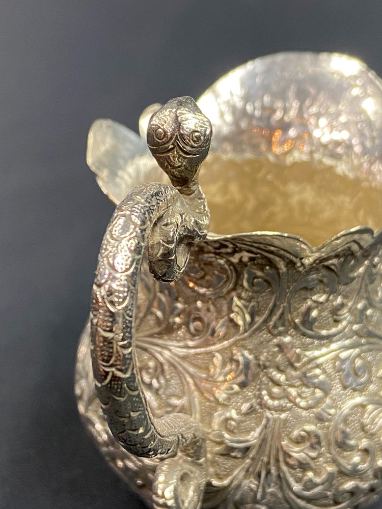 Milk jug in richly chased solid silver with Indo-Persian design and cobra handle