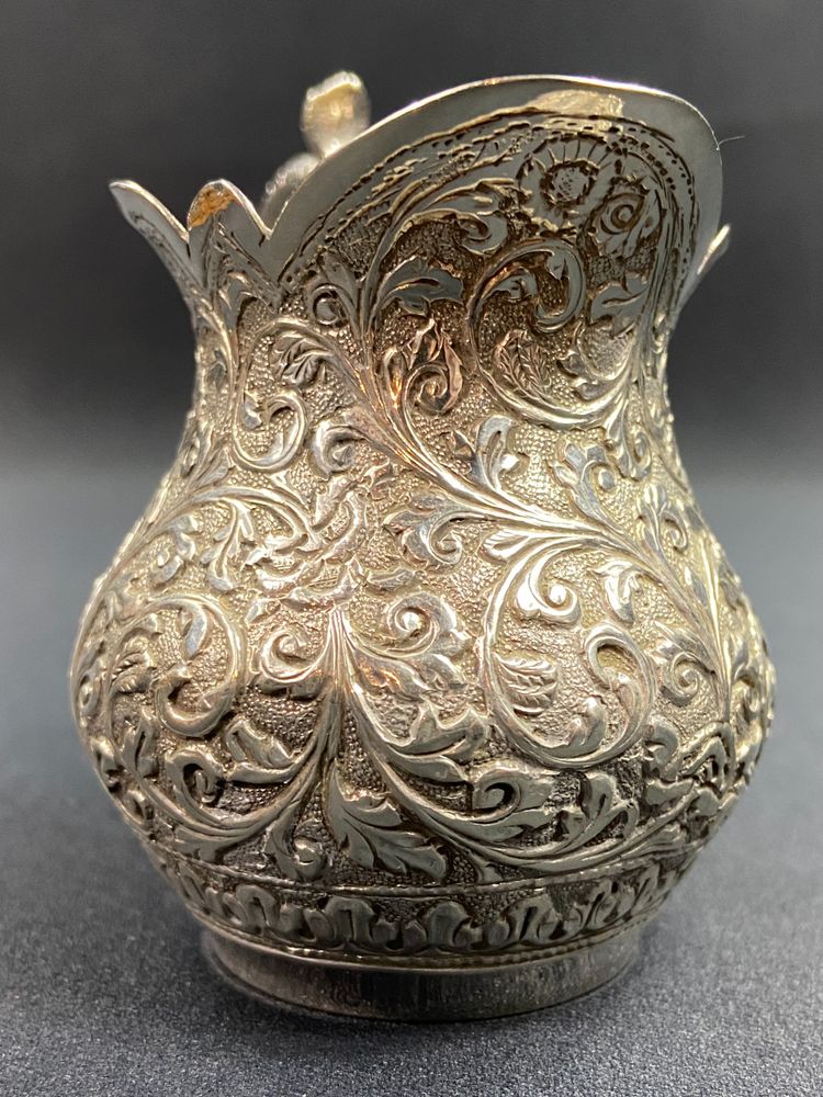 Milk jug in richly chased solid silver with Indo-Persian design and cobra handle