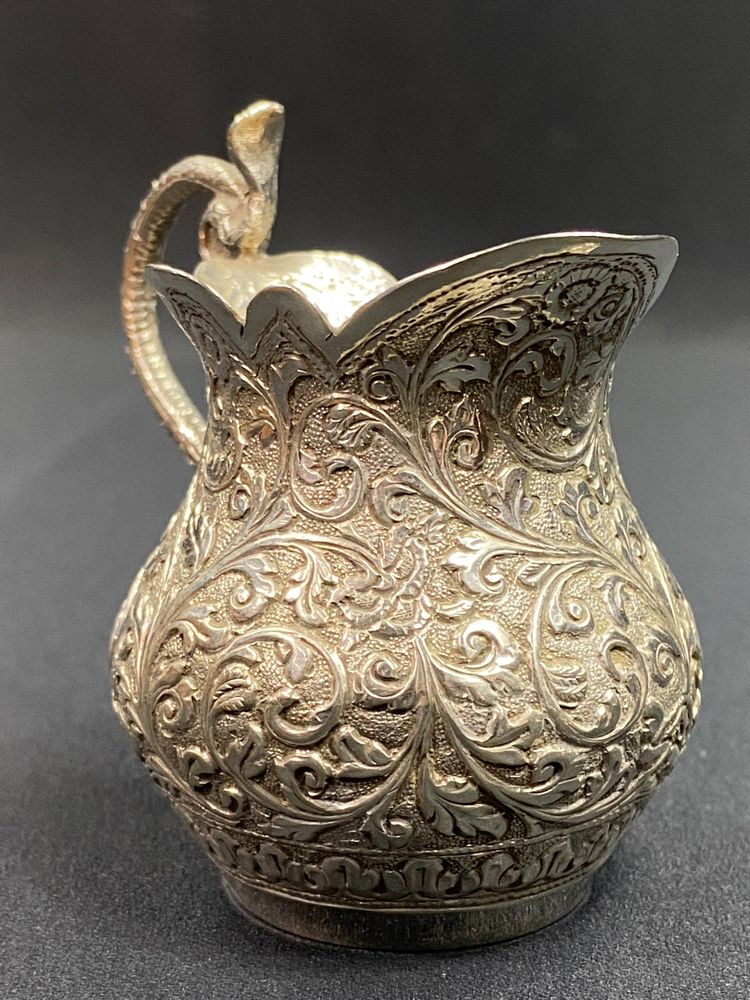 Milk jug in richly chased solid silver with Indo-Persian design and cobra handle