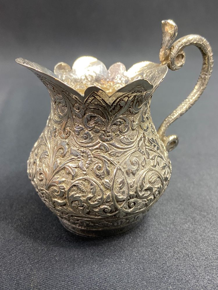 Milk jug in richly chased solid silver with Indo-Persian design and cobra handle