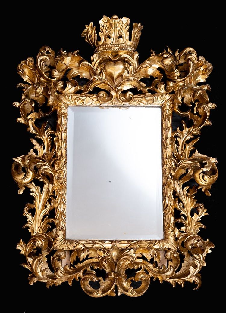 Antique mirror with scrolls in gilded and carved wood. Florence, 18th century.