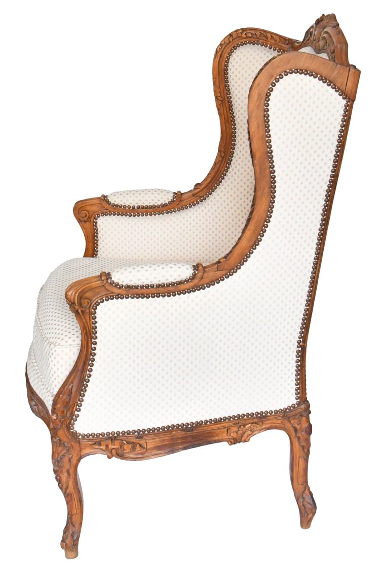 Louis XV style wing chair in richly carved wood