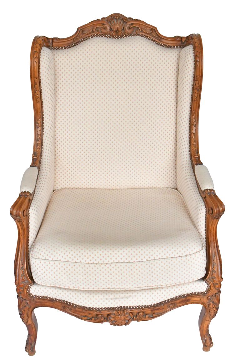 Louis XV style wing chair in richly carved wood