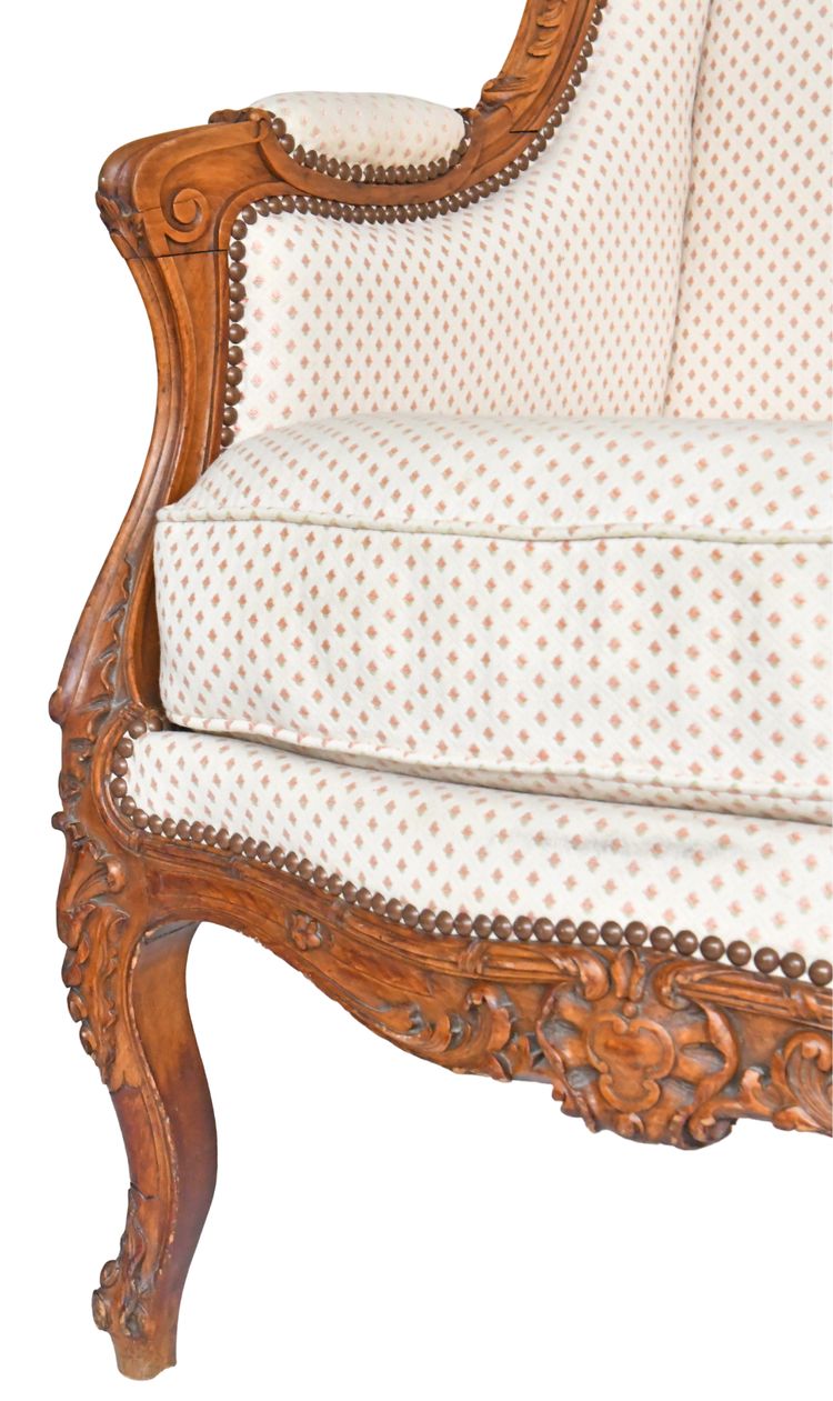 Louis XV style wing chair in richly carved wood